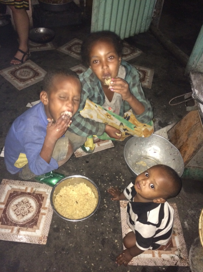 the street kids in Hirna, Ethiopia, offer to share their dinner